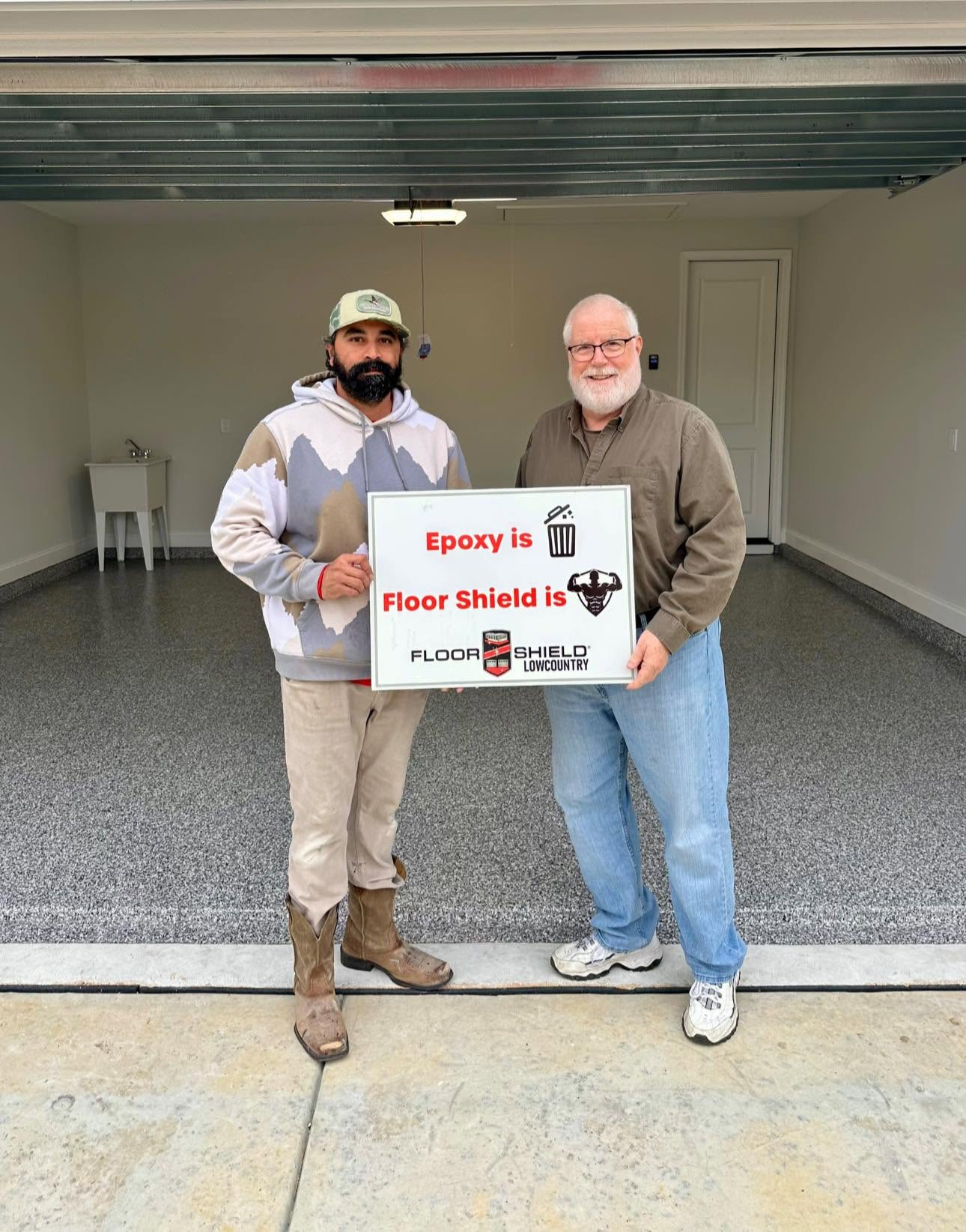 Two homeowners with an I love my new floor sign